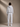 Person wearing a gray hoodie and sweatpants set on a beige background